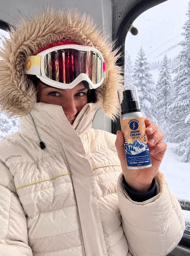 Woman applying Barreltopia face sunscreen in the snow